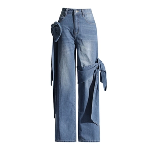 Détail d'un jean bleu à taille haute et jambe large avec décoration de nœud en denim unique