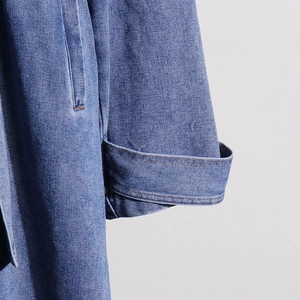Detail of blue denim coat cuff with adjustable strap and premium stitching quality