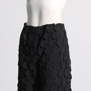Detailed view of black high waist pants featuring unique 3D honeycomb textured embroidery