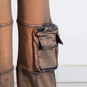 Detail of cargo pants showing the 3D pocket with silver zipper and washed denim texture