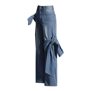 Détail d'un jean large avec décoration de nœud en denim sur le côté de la jambe