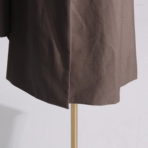 Detail of the brown wool blend blazer hemline showing side slit and fabric texture