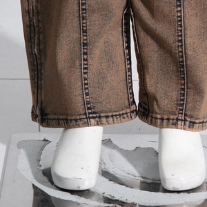 Detailed close-up of side ankle zippers on vintage washed brown cargo denim pants