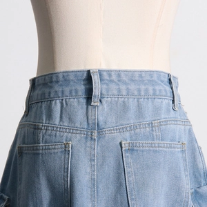 Detailed view of high-waist light blue washed denim skirt with reinforced stitching
