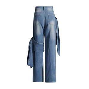 Vue détaillée du jean taille haute à jambe large avec design asymétrique en tissu drapé