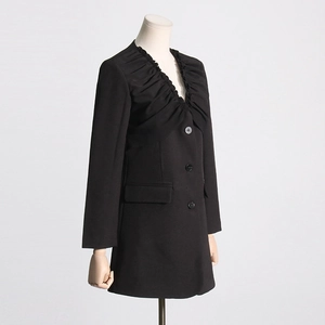 Detail of creative pleated design on black longline blazer with single-breasted buttons