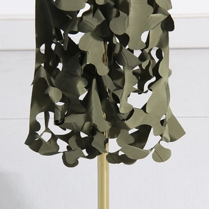 Detail of army green skirt featuring intricate laser-cut hollow camouflage patterns