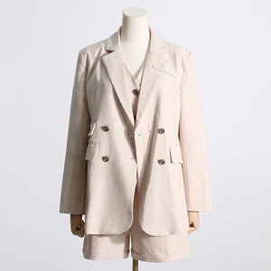 Gros plan détaillé de l'ensemble trois pièces beige avec veste croisée et gilet assorti