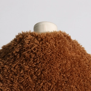 Macro view of plush brown faux shearling texture on a stylish long trench coat detail