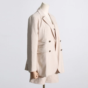 Détail d'un ensemble blazer beige montrant le tissu en lin et coton et la poche à rabat