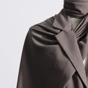 Close-up of soft charcoal grey scarf draped elegantly on a slim-fit blazer for women