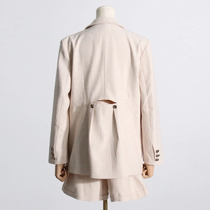Vue détaillée du dos d'un blazer rose avec découpe ajourée et boutons décoratifs