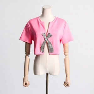 Close-up of pink slim fit tee with sparkling rhinestone bow buckle and pearl details