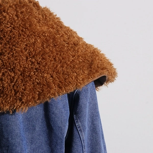 Detail of brown faux shearling collar paired with blue denim fabric for a stylish coat