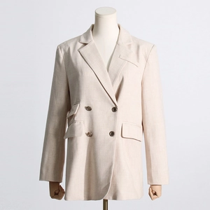 Détail d'un blazer en lin beige avec revers à pointe et doubles poches à rabat