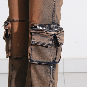 Detail of washed cargo pants featuring 3D side pockets and silver metal zippers