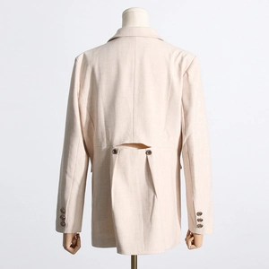 Vue détaillée du dos d'un blazer beige avec découpe à la taille et boutons métalliques