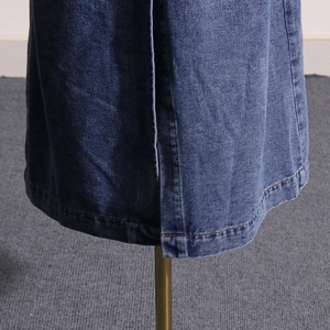 Detail view of denim skirt side slit with high-quality stitching and twill texture