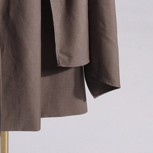 Detail of coffee brown blazer coat showing double-layer tailoring and twill fabric texture