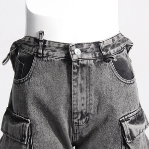 Detailed macro view of vintage wash cargo denim jeans with contrast pockets and buckles