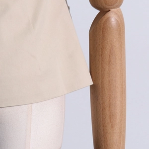 Détail de l'ourlet en coton kaki avec coutures précises présenté sur un mannequin de bois