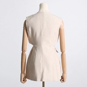 Détail de la robe gilet sans manches beige avec découpes à la taille et texture en lin