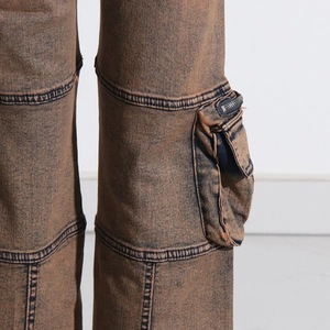 Detail of vintage brown washed denim pants showing cargo pocket and zip hardware