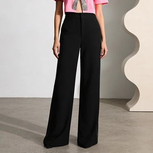 Detail of high-waisted black wide-leg trousers with elegant drape and side rhinestone accents