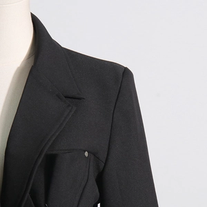 Detailed view of the peak lapel and padded shoulder on this black tailored blazer