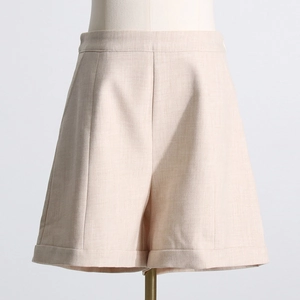 Détail du short de costume taille haute abricot avec plis et ourlet revers pour femme