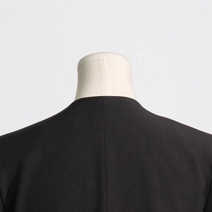 Close-up of the back neckline and fine stitching of a black V-neck slimming blazer
