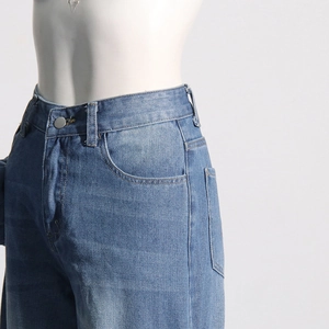 Vue détaillée du jean taille haute avec délavage vintage et bouton en métal durable
