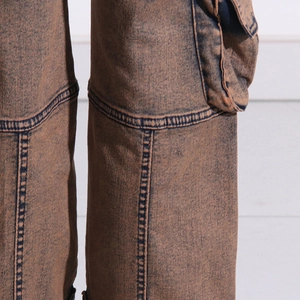 Macro detail of acid-washed brown cargo pants featuring reinforced double-needle stitching