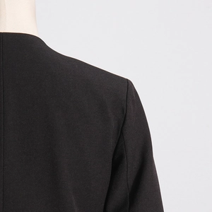 Detailed view of the shoulder stitching and fabric texture of a black blazer
