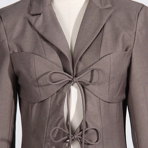 Detail of elegant waist tie-up and hollow-out design on a slim-fit khaki blazer