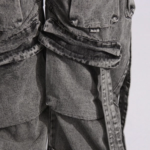 Detailed view of cargo denim pants with large pockets and faded wash finish