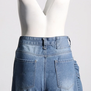 Détail des poches arrière et de la taille haute du jean bleu avec passants sur un mannequin