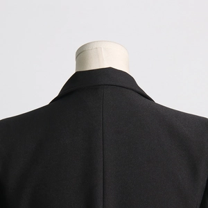 Close-up of black blazer rear neckline and shoulder seam on a mannequin display