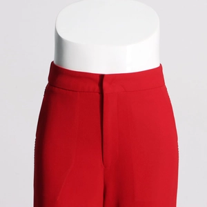 Detailed close-up of high-waist red dress pants showing smooth fabric and waistband