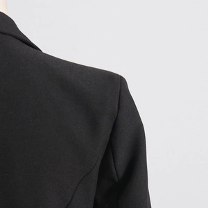 Close-up of structured shoulder on black blazer showing high-quality stitching and texture