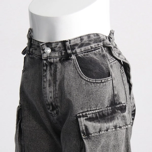 Detail of grey washed cargo jeans featuring large side pockets and metal button closure