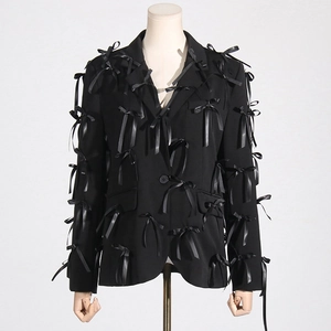 Detail of black blazer featuring 3D satin bows and single-breasted classic notch lapel
