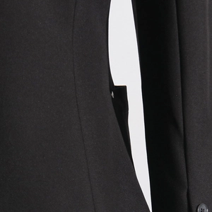 Detailed close-up of a black blazer's side buckle and structural fabric seams