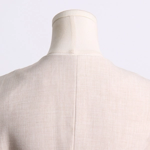 Gros plan du col arrière et des coutures d'un blazer beige clair au fini lin