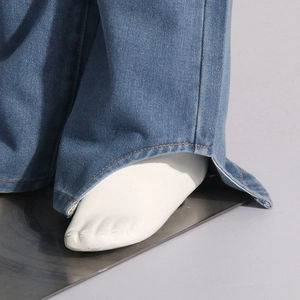 Détail du bas de jean en denim avec fente latérale et surpiqûres jaunes contrastées