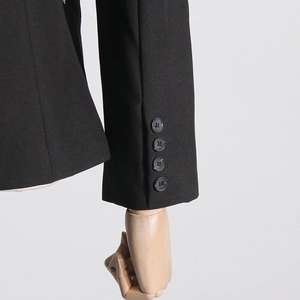 Detailed macro view of black blazer cuffs featuring four decorative buttons and fabric texture