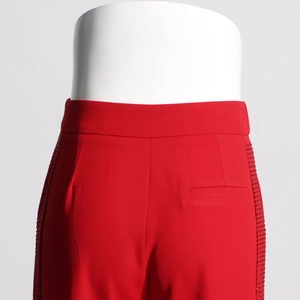 Detail of high-waist red dress pants with side bead embellishments and welt pocket back view