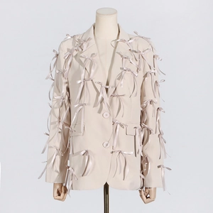 Detail of handmade satin bows on a beige V-neck tailored blazer for women