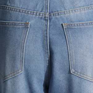 Détail d'un jean bleu clair montrant les poches arrière avec surpiqûres jaunes