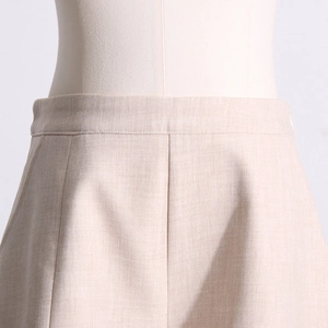 Détail de la jupe professionnelle beige montrant la texture du tissu et les coutures soignées